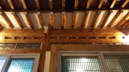 a room with a wooden ceiling and two windows at Hwangridangil Adamjeong in Gyeongju