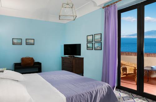 a bedroom with a bed and a view of the ocean at Hotel Minerva in Sorrento