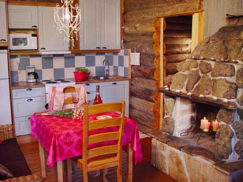 cocina con mesa y chimenea de piedra en Holiday Home Rinnekämppä by Interhome en Pätiälä