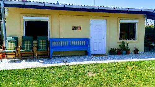 a blue bench sitting in front of a house at Kukucs Etyek Dézsafürdő Vendégház in Etyek