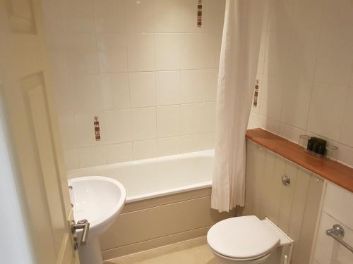 a bathroom with a sink and a toilet and a tub at Rose And Crown in Porthcawl