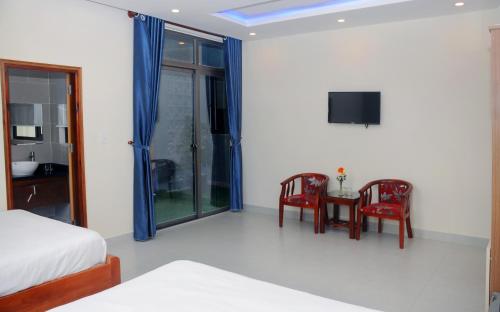 a bedroom with a bed and a table and chairs at Melody Boutique Villa Hoi An in Hoi An