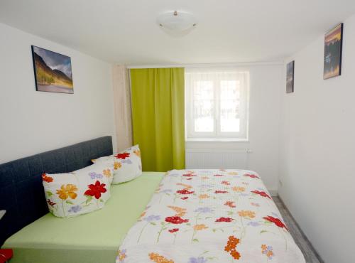 a bedroom with a bed with a floral comforter and a window at Grafenblick, Ferienwohnung mit Aussicht! in Elbe