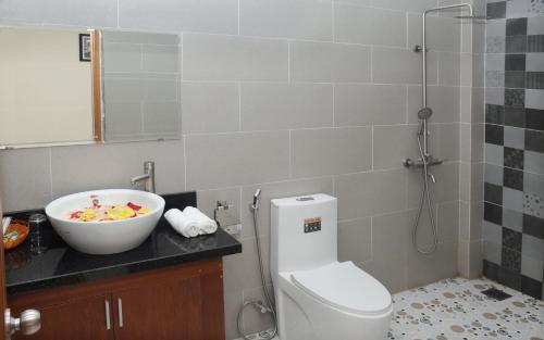 a bathroom with a sink and a toilet and a bowl at Melody Boutique Villa Hoi An in Hoi An