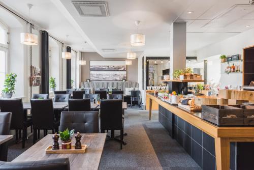 a restaurant with a bar and tables and chairs at Home Hotel Bilan in Karlstad