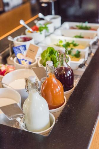 a buffet with many different types of bottles of milk at Home Hotel Bilan in Karlstad