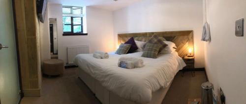 a bed with white sheets and pillows in a room at The Wiremill Sleep Boutique in Felbridge