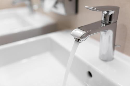 a bathroom sink with a water faucet at Hotel Alte Bäckerei in Nidderau