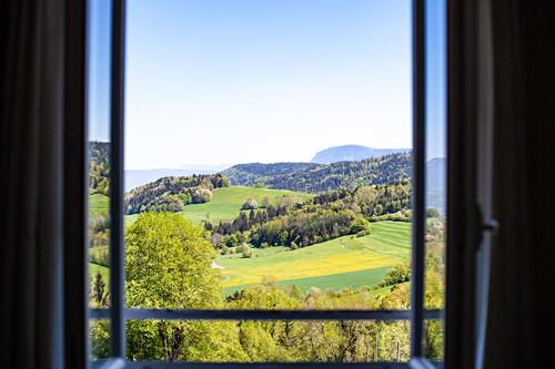 a window with a view of a green field at Monchateau étoilé, hébergement insolite avec Spa in Merlas