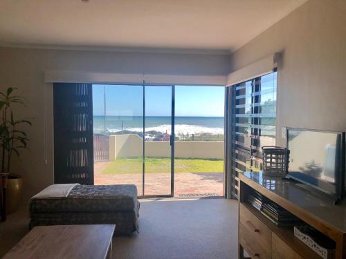 a living room with a view of the ocean at Beachfront Apartment at Malata Beach in Blouberg in Bloubergstrand
