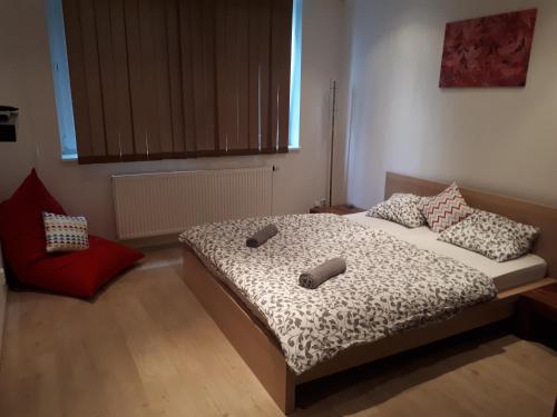 une chambre avec un lit et une chaise rouge dans l'établissement Útulný apartmán v Bratislava 6, à Bratislava