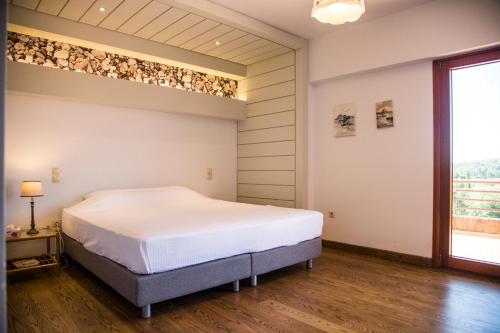 um quarto com uma cama grande e uma janela em Mediterra retreat em Kapandrítion