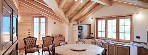 - une cuisine avec un plafond en bois, une table et des chaises dans l'établissement Casa Vacanza in tipico Chalet di montagna, à Varzo