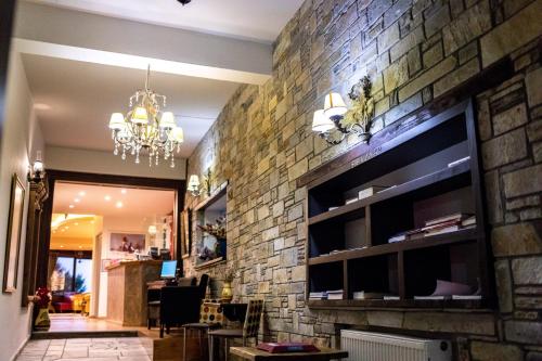 a living room with a brick wall and a chandelier at Tasia Mountain Hotel in Chania