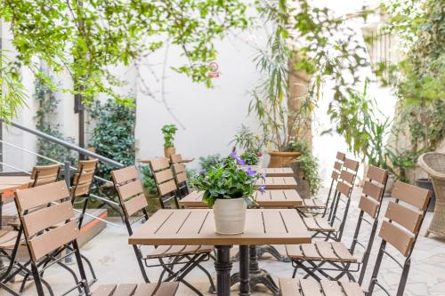 a table and chairs on a patio with plants at Hôtel Central in Avignon