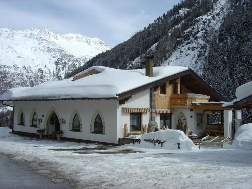 a house covered in snow in front of a mountain at Apart Gentiana in Sölden