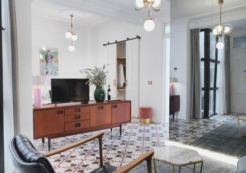 a living room with a television on a wooden cabinet at Casa Timoteo Apartamentos Boutique Adults Only in Alcoy