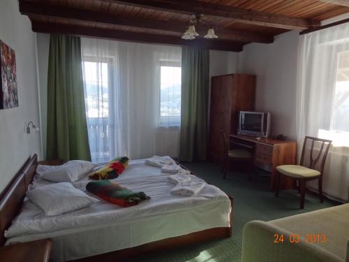 a bedroom with a large bed and a desk at Alpenhof Pansion in Slavske