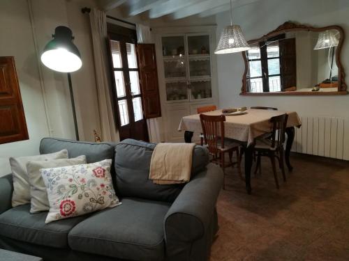 ein Wohnzimmer mit einem blauen Sofa und einem Tisch in der Unterkunft Allotjament turístic Cal Minguell in San Lorenzo de Morunys