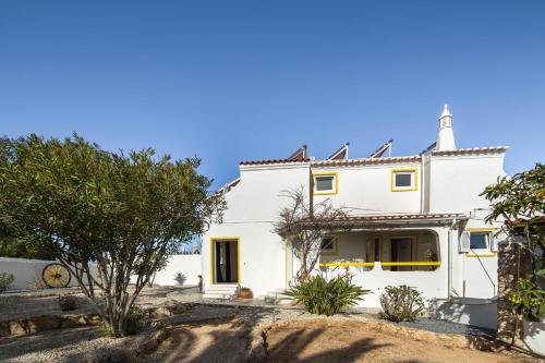 a white house with a tree in front of it at Vila Horizonte in Carvoeiro