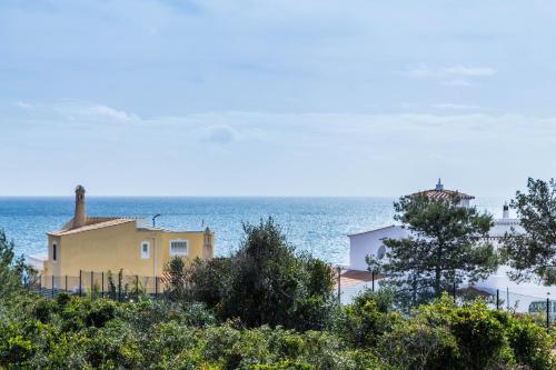 a yellow house on a hill near the ocean at Vila Horizonte in Carvoeiro