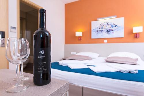 a bottle of wine sitting on a table with a glass at Apartments Villa Loznica in Brela