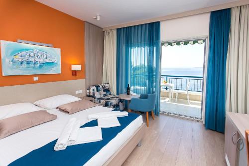 ein Hotelzimmer mit einem Bett, einem Schreibtisch und einem Fenster in der Unterkunft Apartments Villa Loznica in Brela