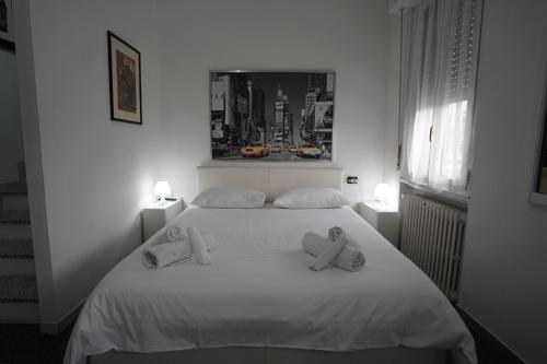 Un dormitorio con una cama blanca con dos ositos de peluche. en Ciro BED AND BREAKFAST la villetta, en Pioltello