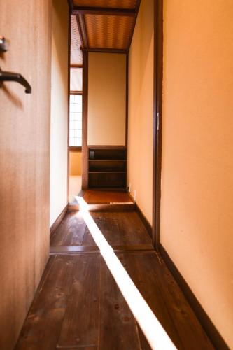 an empty hallway with a door and a beam of light at Kyo no Yado Sangen Ninenzaka in Kyoto