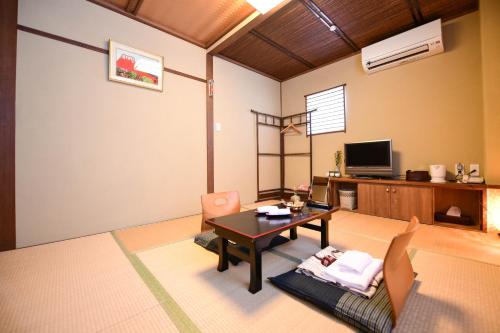 a living room with a table and chairs at Kyo no Yado Sangen Ninenzaka in Kyoto