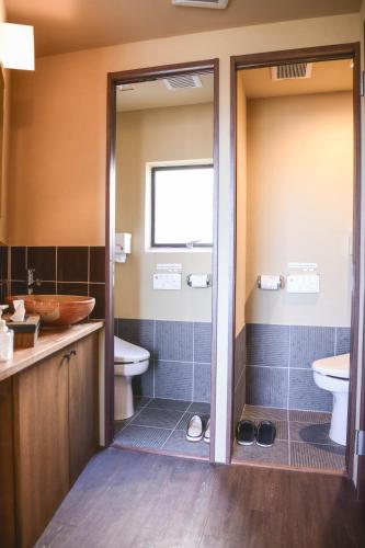 a bathroom with a shower and a toilet and a sink at Kyo no Yado Sangen Ninenzaka in Kyoto