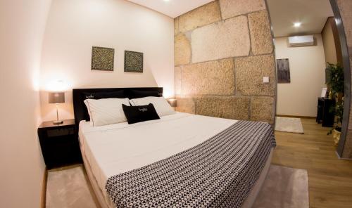 ペーゾ・ダ・レーグアにあるBugalha My Loft Douro 2の石壁のベッドルーム1室(大型ベッド1台付)