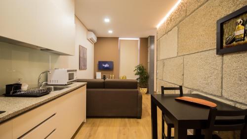 a kitchen and living room with a couch and a table at Bugalha My Loft Douro 2 in Peso da Régua