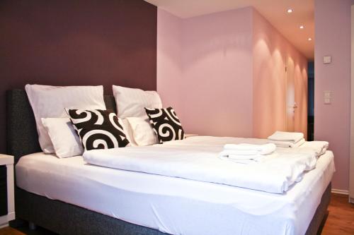 uma grande cama branca com almofadas pretas e brancas em Haus Elisabeth em Bad Salzungen