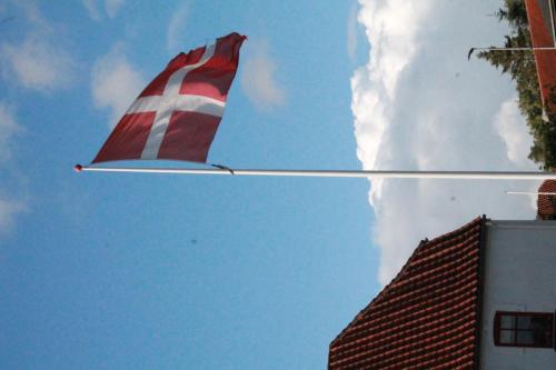 a red and white kite flying in the sky at Hotel Rødding in Rødding