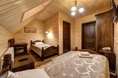 a bedroom with two beds in a room with wooden walls at Continental SPA Resort in Bukovel