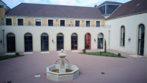 パライユ・ル・モニアルにあるMédicis Home Paray le Monialの中庭中央に噴水のある建物