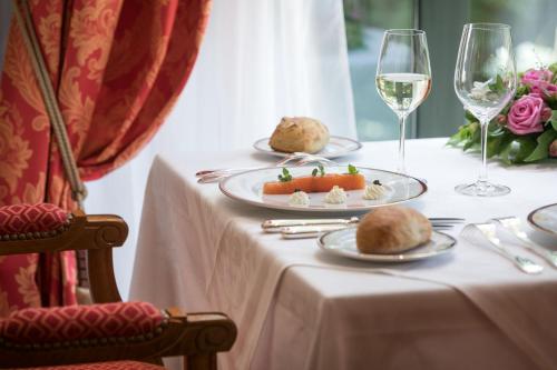帕萊勒蒙尼亞勒的住宿－Médicis Home Paray le Monial，一张桌子,上面放着两盘食物和一杯葡萄酒