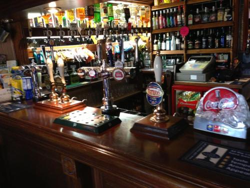 a bar with a counter withbeer bottles and candles at The Golden Lion Hotel in Middlewich