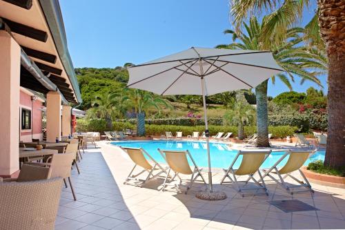 a pool with chairs and a table with an umbrella at Hotel Corallaro in Santa Teresa Gallura