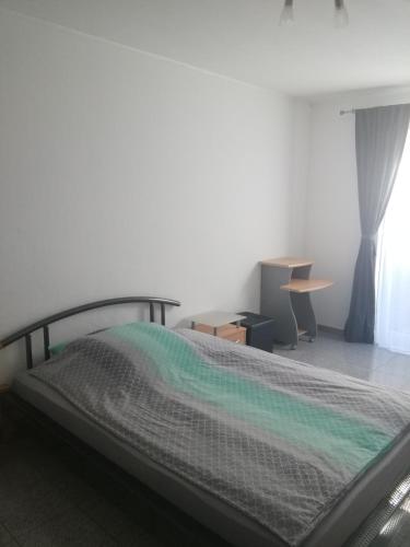 a bedroom with a bed and a desk and a window at Moderne Wohnung in Elz in Elz
