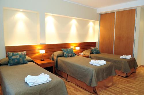 a hotel room with two beds with towels on them at Parque Hotel in Villa Carlos Paz