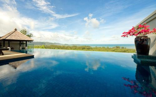 a swimming pool with a gazebo and the ocean at The Pavilions Phuket in Bang Tao Beach