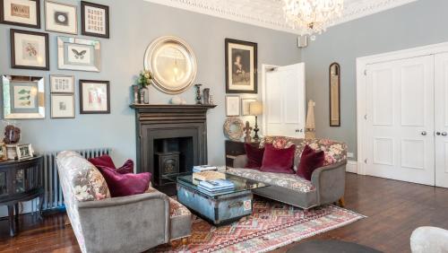 a living room with two chairs and a fireplace at Didsbury House Hotel in Manchester