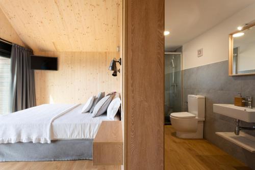a bedroom with a bed and a toilet and a sink at Cabañas de Canide in A Coruña