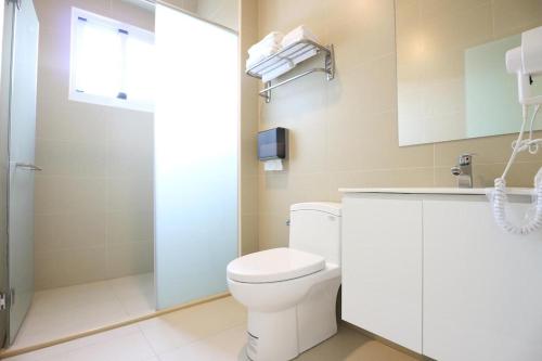 a bathroom with a toilet and a shower at Cozy Green Guesthouse in Taitung City