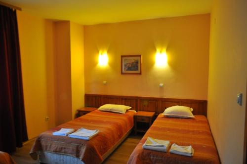 two beds in a room with yellow walls at Family Hotel Bansko Sofia in Sofia