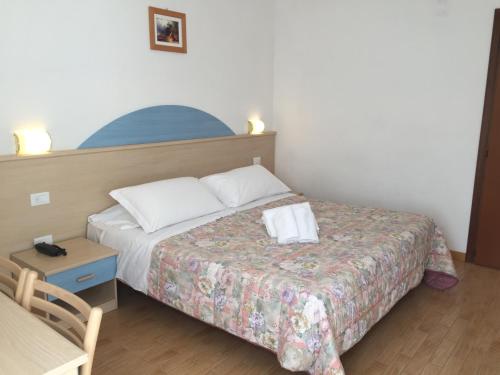 a bedroom with a bed and a table and a chair at Hotel alle Rose in Cavedago