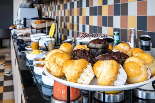 ein Tablett mit Gebäck und Gebäck auf einem Buffet in der Unterkunft Hôtel Mercure Paris Gennevilliers in Gennevilliers