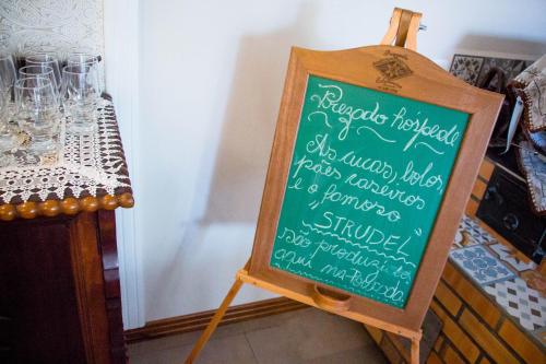 a chalkboard sign on a stand next to a table at Edelweiss Pomerode in Pomerode